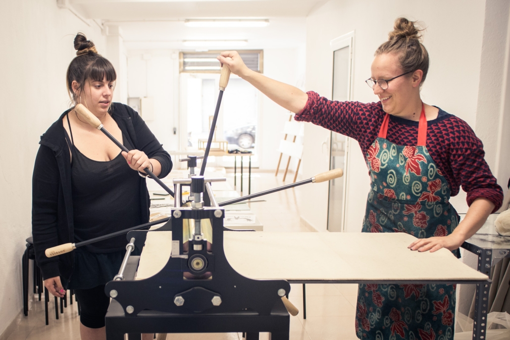 Two girls with a manual print machine